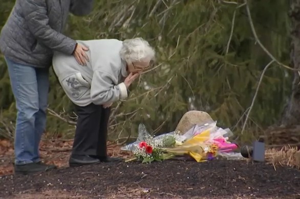 The great-grandmother of two slain children, Cora and Dawson Clancy, leaves flowers at their home on Summer Street in Duxbury, Massachusetts, on Wednesday, Jan. 25, 2023, a day after they were allegedly killed by their mother.
